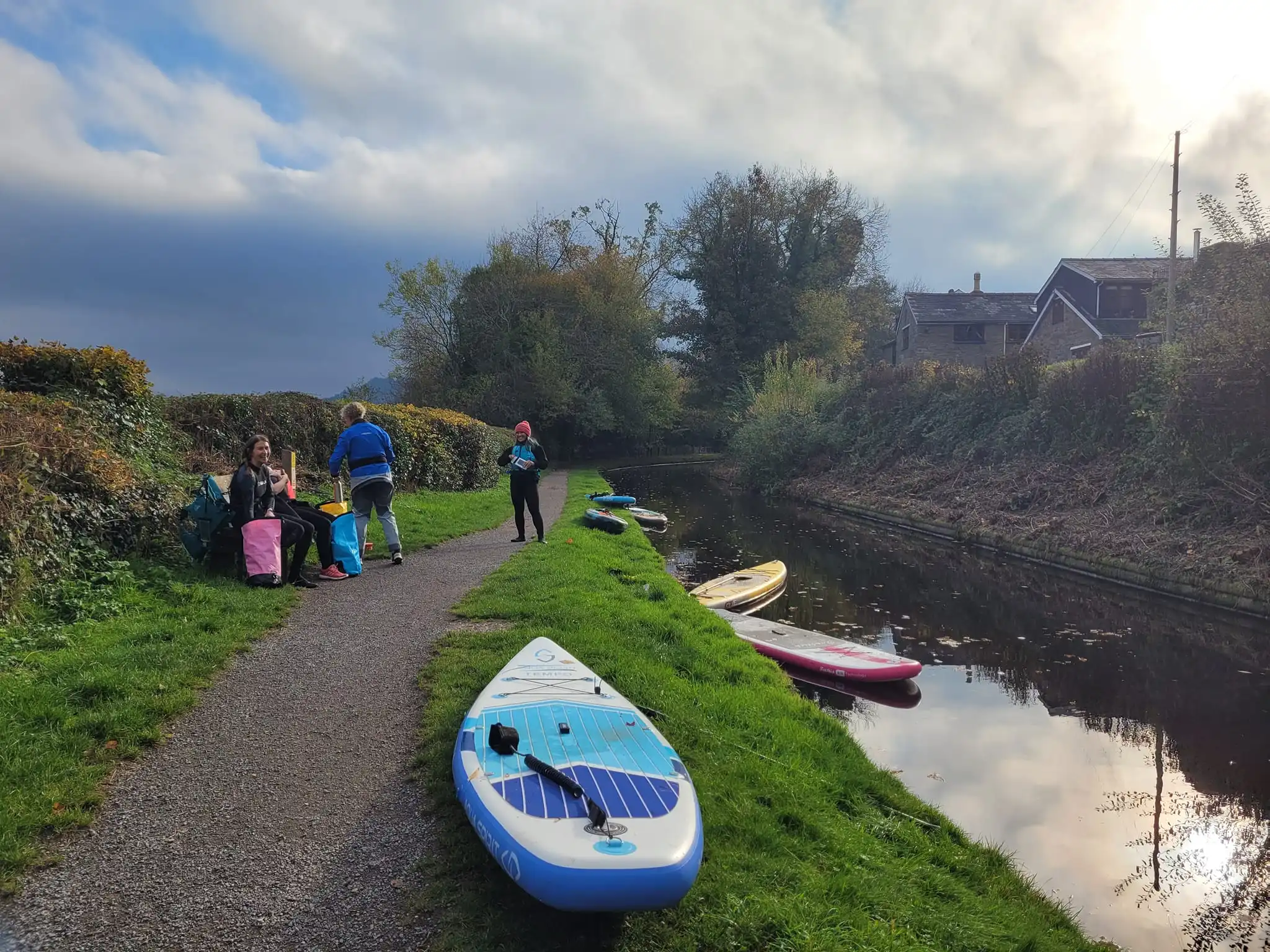 Group of paddleboarders taking a break on canal towpath