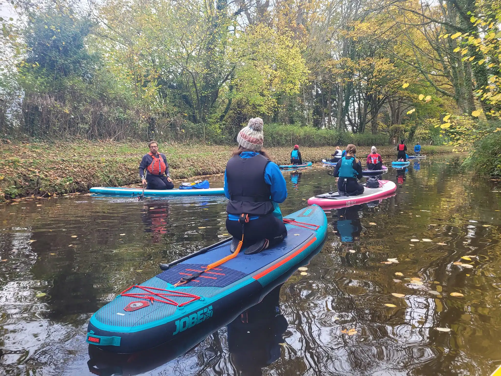 Group of paddleboarders taking a break on canal