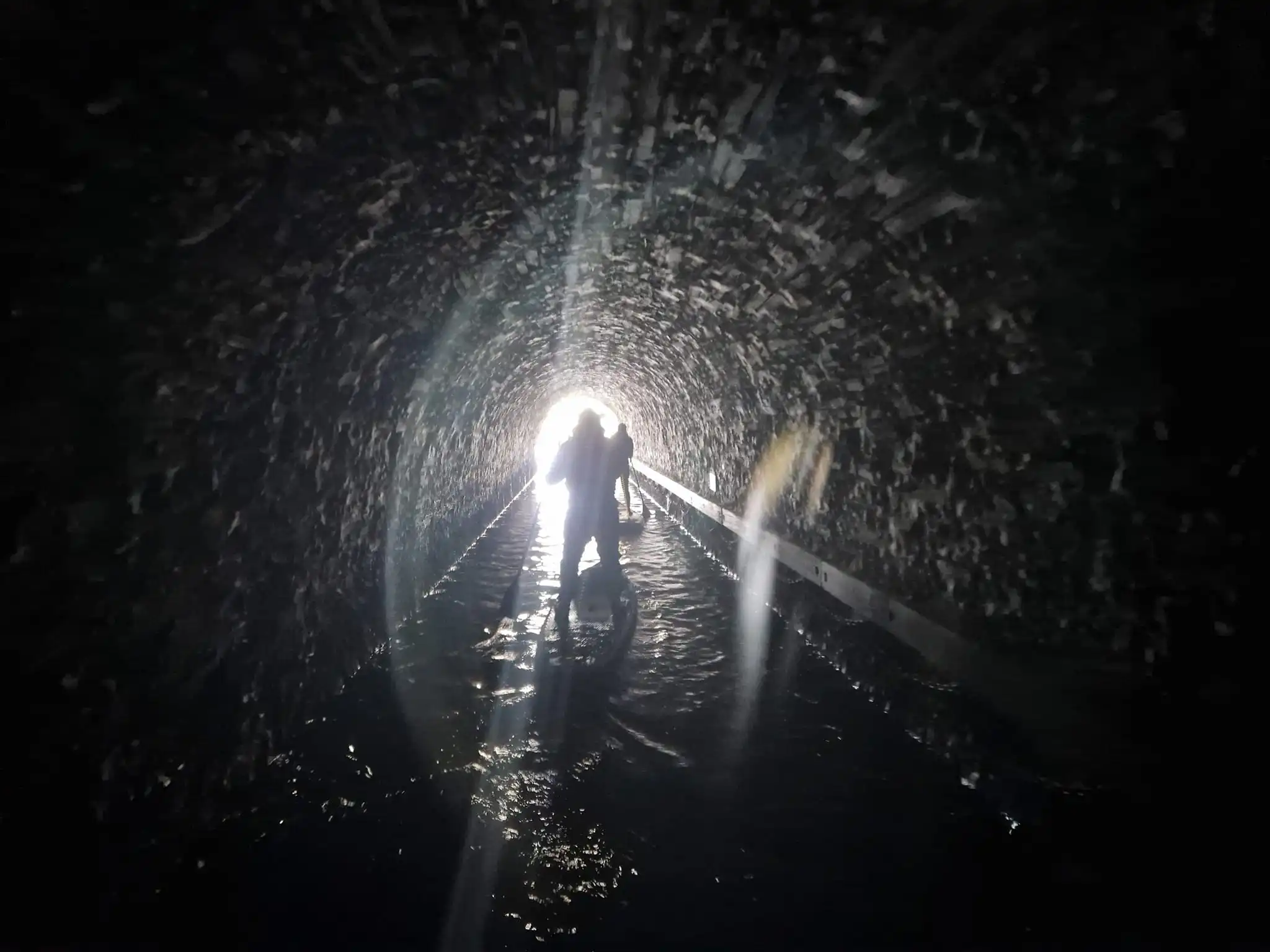 Paddleboarders in canal tunnel