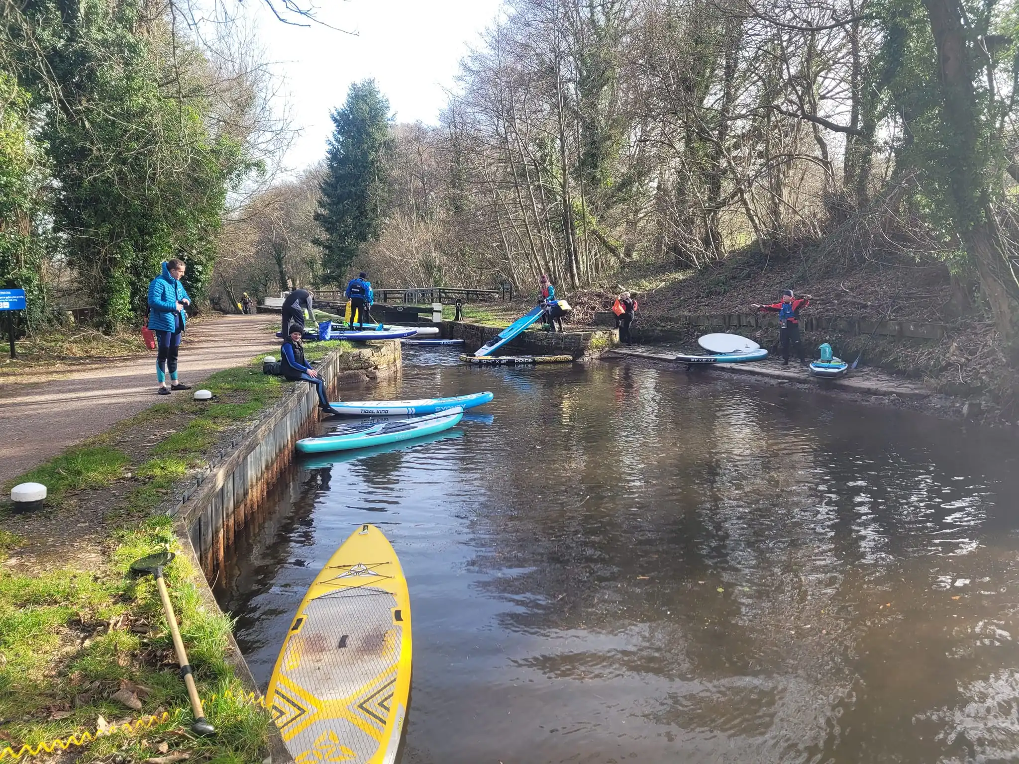 Group of paddleboarders taking a break on canal towpath